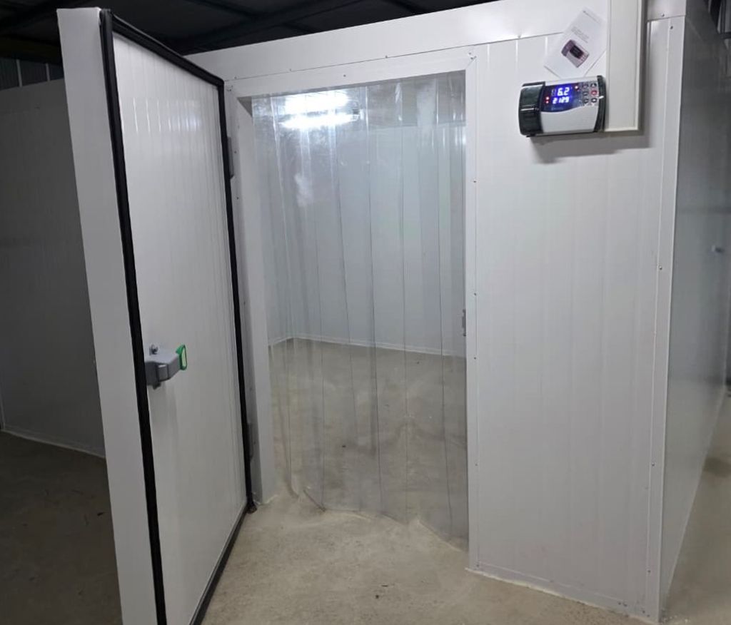 Cámara de mantención CHILETG instalada en galpón, con la puerta abierta